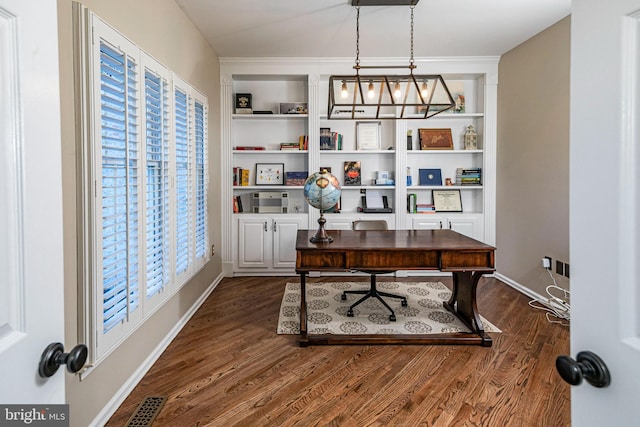 office featuring built in shelves and dark hardwood / wood-style flooring