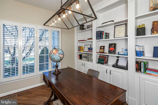 home office featuring crown molding, dark hardwood / wood-style flooring, a chandelier, and built in features