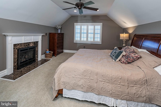 bedroom featuring carpet flooring, ceiling fan, lofted ceiling, and a premium fireplace