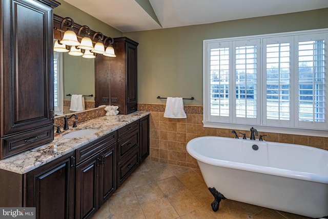 bathroom with tile patterned flooring, a bath, vanity, and tile walls