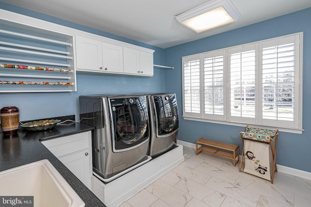 washroom featuring cabinets, sink, and washing machine and dryer