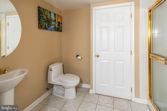 bathroom with tile patterned flooring, toilet, a shower with door, and sink