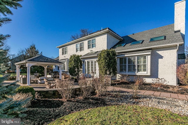 rear view of house with a patio area and an outdoor living space