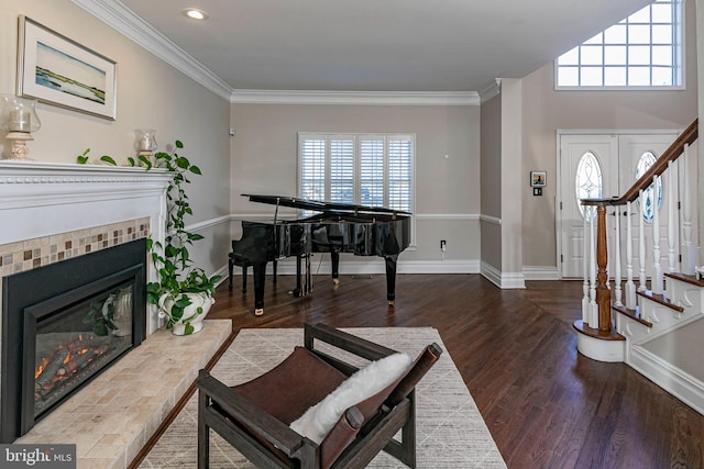 foyer with a fireplace, wood-type flooring, and ornamental molding