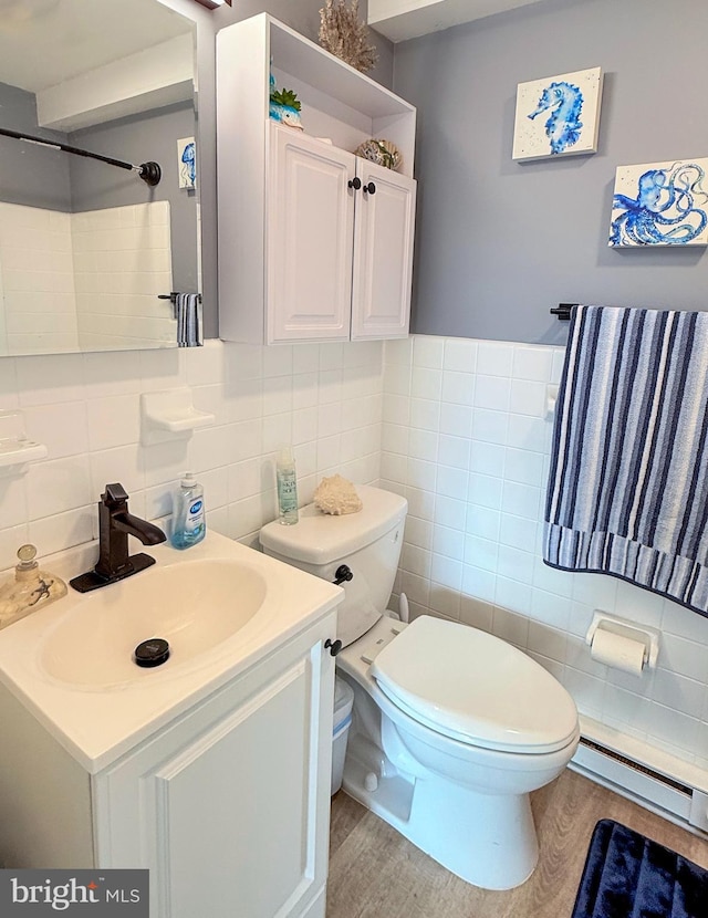 bathroom with decorative backsplash, vanity, a baseboard heating unit, hardwood / wood-style flooring, and toilet