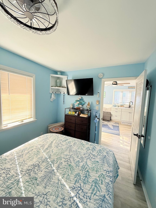 bedroom featuring light wood-type flooring and sink