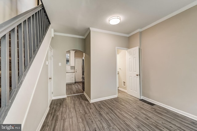 spare room featuring wood-type flooring and ornamental molding