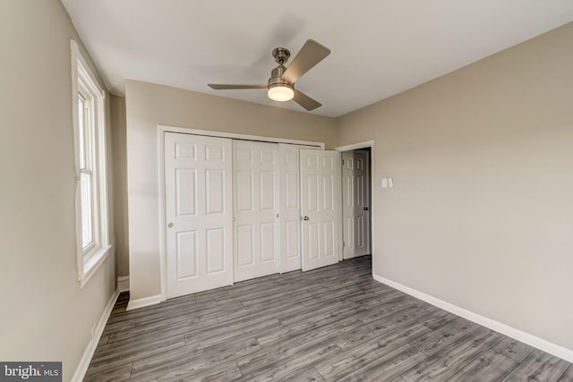 unfurnished bedroom with ceiling fan, a closet, and wood-type flooring