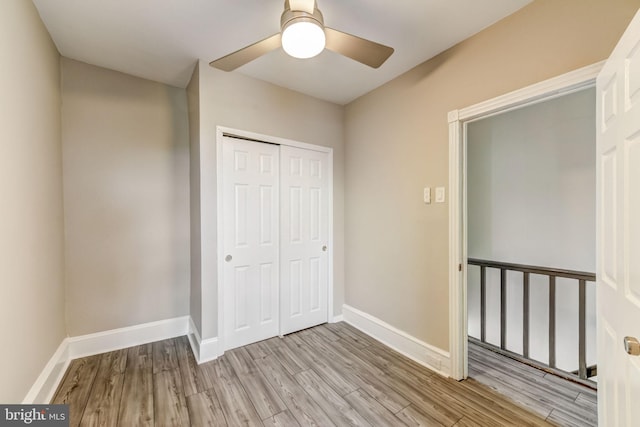 unfurnished bedroom featuring ceiling fan, a closet, and light hardwood / wood-style flooring