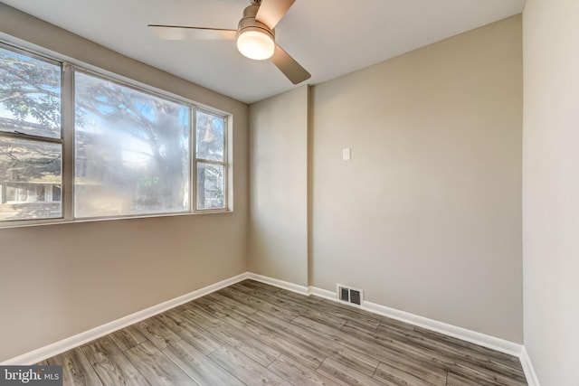 spare room featuring wood-type flooring and ceiling fan