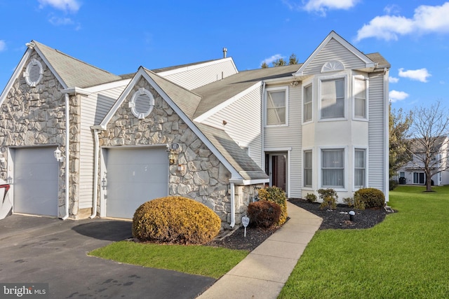 townhome / multi-family property featuring a front yard and a garage