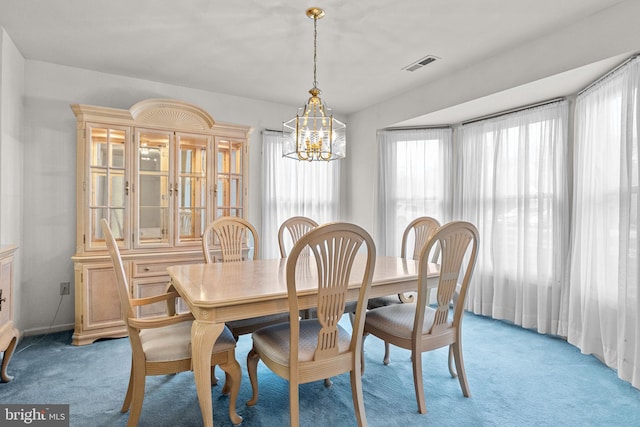 carpeted dining room with a notable chandelier