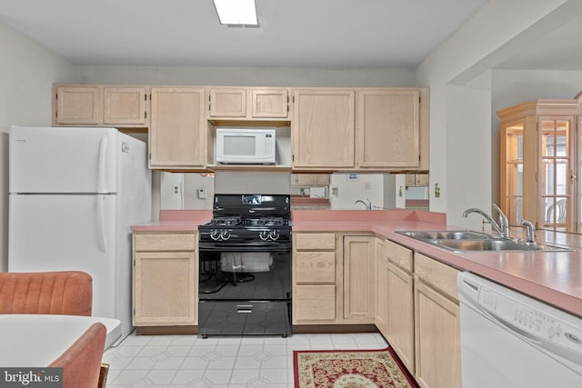 kitchen with light brown cabinetry, white appliances, and sink