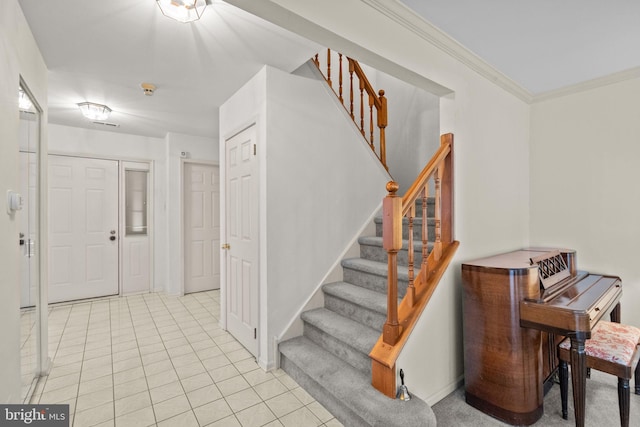 entrance foyer featuring crown molding and light tile patterned flooring