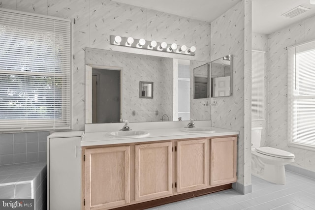 bathroom featuring tile patterned floors, vanity, a healthy amount of sunlight, and toilet