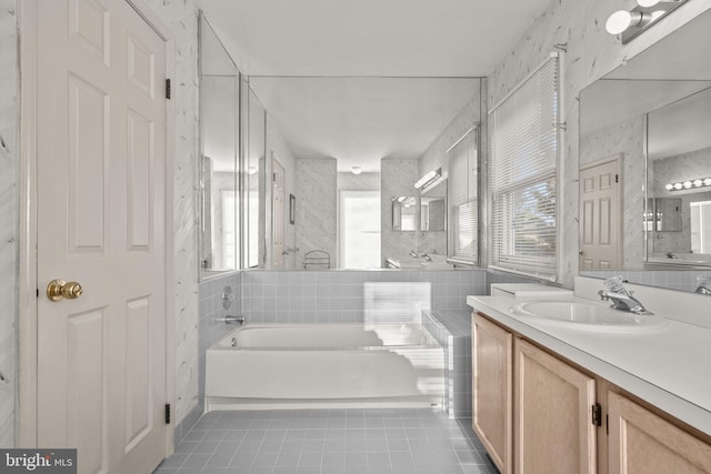 bathroom with a bathing tub, tile patterned flooring, and vanity