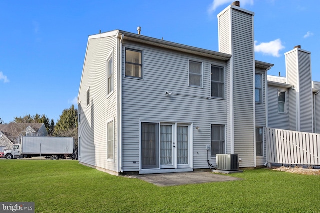 back of property with cooling unit, a patio area, and a yard