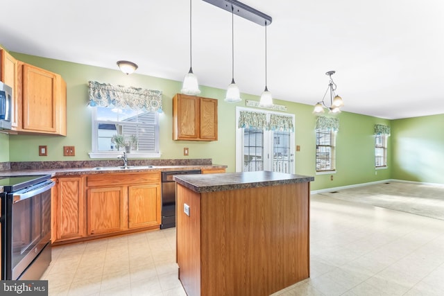 kitchen with decorative light fixtures, a kitchen island, an inviting chandelier, appliances with stainless steel finishes, and sink