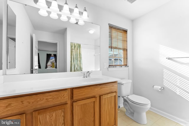 bathroom with tile patterned flooring, curtained shower, vanity, and toilet