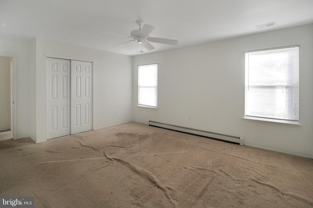 unfurnished bedroom with ceiling fan, a closet, carpet, and a baseboard radiator