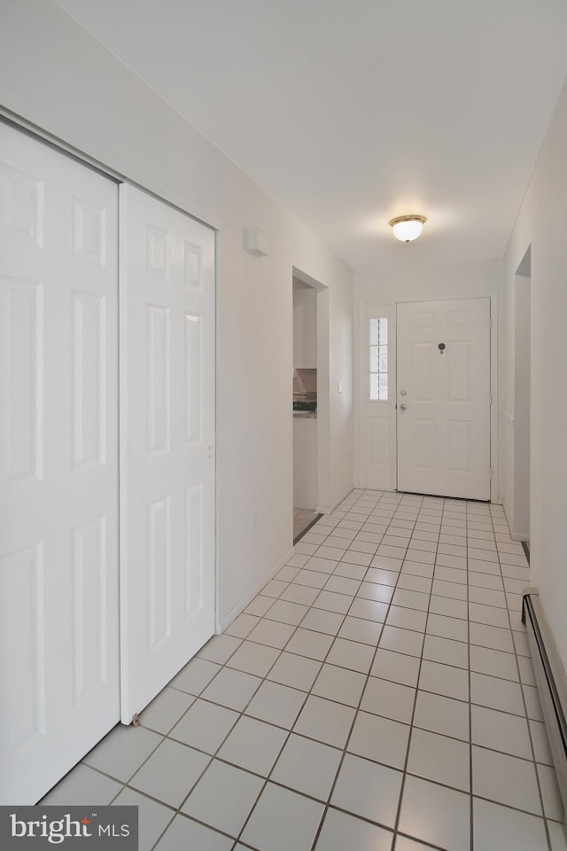 tiled entrance foyer with a baseboard heating unit