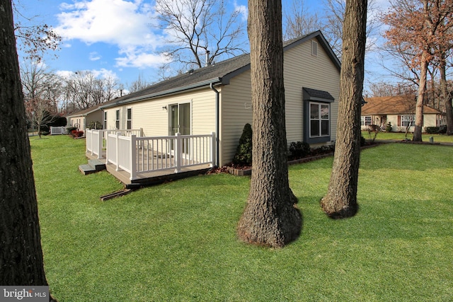 back of property with a deck and a yard