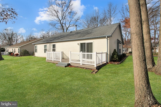 back of property with a deck and a yard