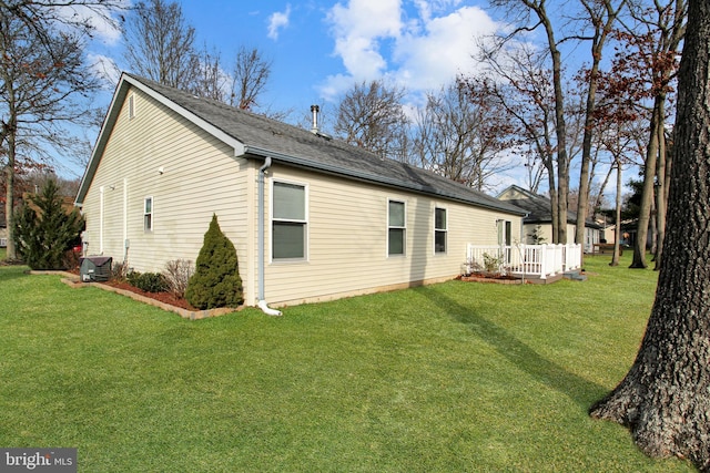 rear view of property featuring a wooden deck, a yard, and central AC unit