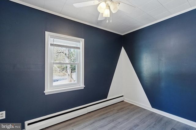 unfurnished room featuring hardwood / wood-style floors, ceiling fan, crown molding, and baseboard heating