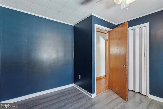 unfurnished bedroom featuring crown molding, ceiling fan, and wood-type flooring