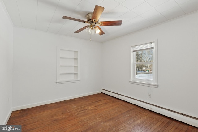 spare room featuring hardwood / wood-style flooring, ceiling fan, built in features, and baseboard heating