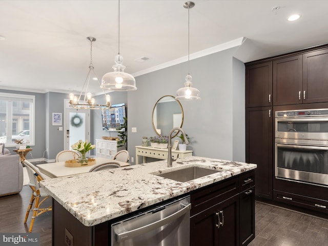 kitchen featuring sink, hanging light fixtures, an island with sink, and appliances with stainless steel finishes