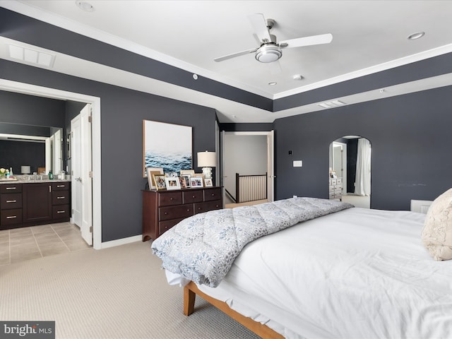 carpeted bedroom featuring ornamental molding, connected bathroom, and ceiling fan