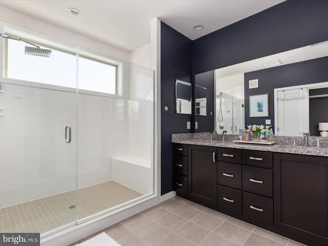 bathroom with tile patterned flooring, vanity, and walk in shower