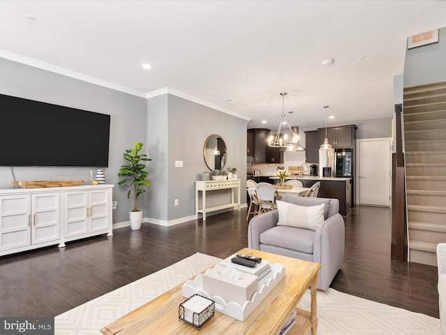 living room featuring crown molding, dark wood-type flooring, and a chandelier