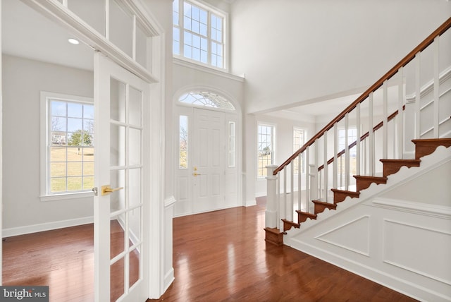 foyer featuring french doors, dark hardwood / wood-style floors, and a towering ceiling