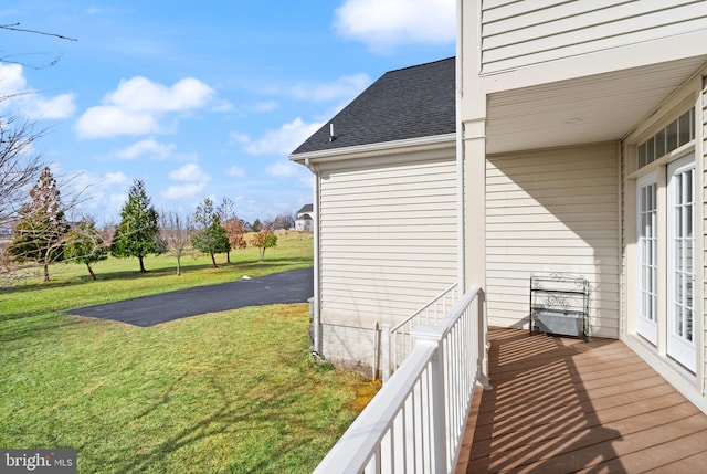 view of side of property featuring a balcony and a yard