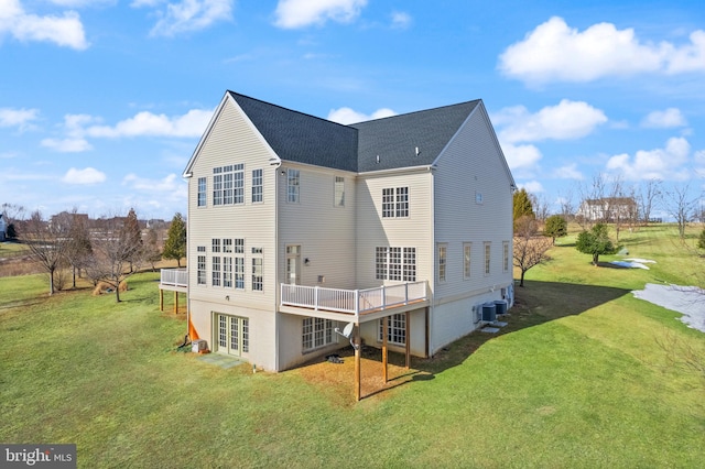 rear view of house featuring french doors, a yard, a deck, and central air condition unit