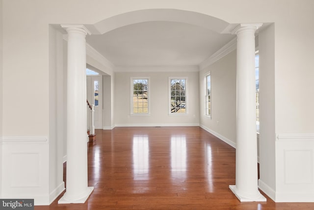 interior space featuring ornate columns, crown molding, and hardwood / wood-style floors