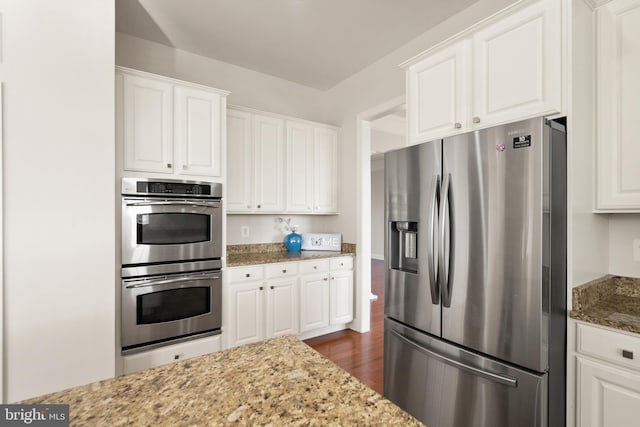 kitchen with white cabinetry, stainless steel appliances, dark hardwood / wood-style flooring, and light stone countertops