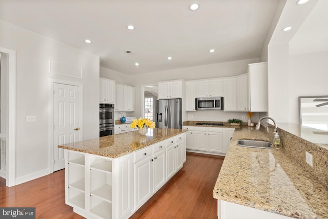 kitchen featuring light stone counters, white cabinetry, a center island, and appliances with stainless steel finishes