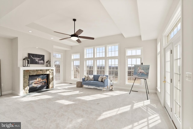 interior space featuring a tiled fireplace and ceiling fan