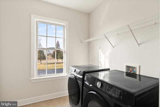 laundry room featuring light tile patterned flooring and washing machine and clothes dryer