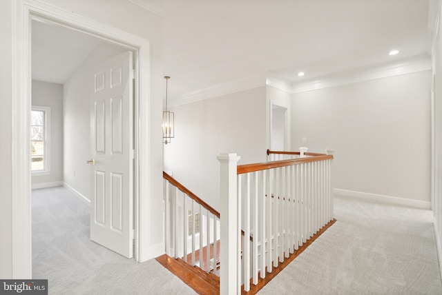 hall with light colored carpet and ornamental molding