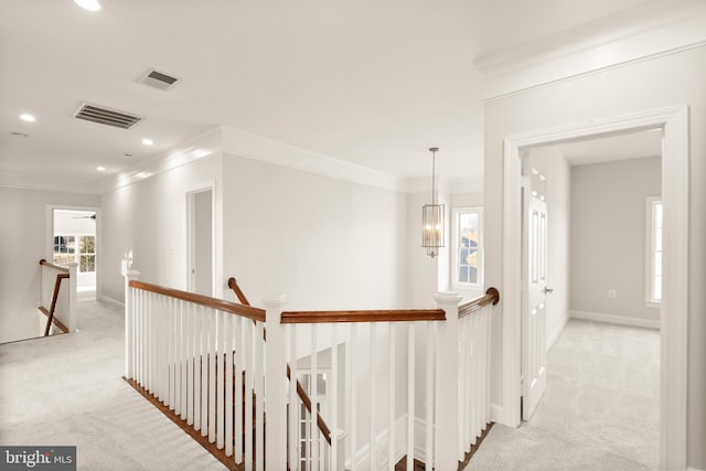 corridor with ornamental molding, light carpet, and a notable chandelier