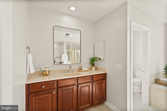 bathroom featuring vanity, tile patterned floors, and toilet