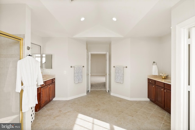 bathroom featuring walk in shower, lofted ceiling, and vanity