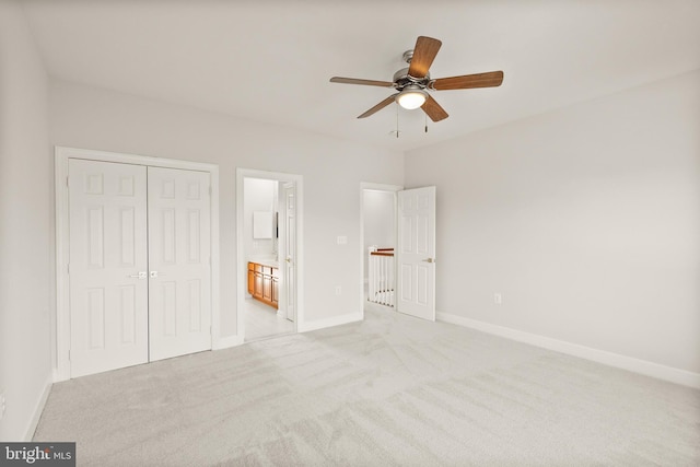 unfurnished bedroom with light carpet, a closet, ceiling fan, and ensuite bathroom