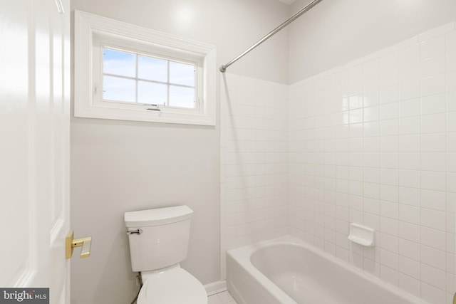 bathroom with tiled shower / bath combo and toilet