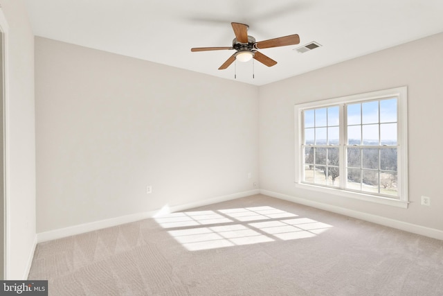 spare room with ceiling fan and light carpet